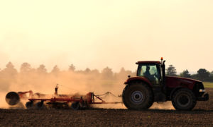 Tractor in field at sunset